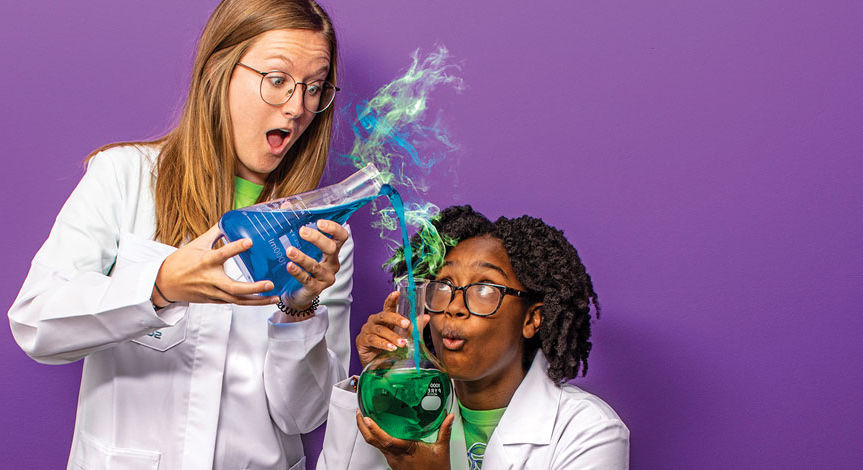 2 mad scientist pouring liquid into a beaker