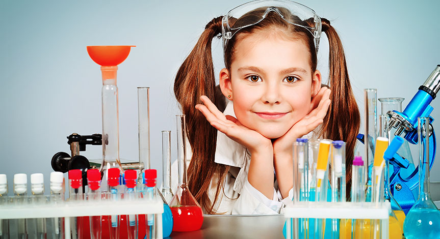 Science Girl with hands under her chin with multi colored test tubes in front of her.