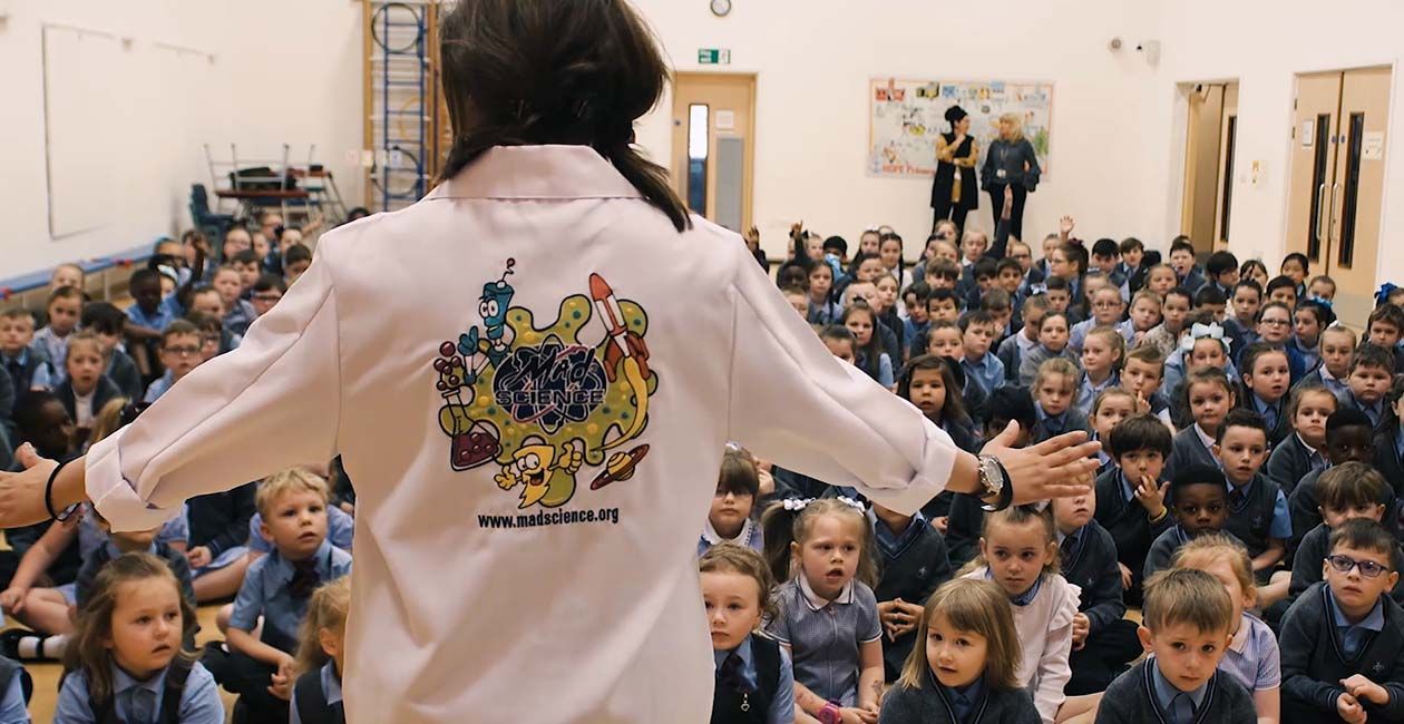 Mad Scientist at special event presenting to room full of children sitting on the floor