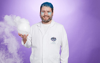 A mad scientist with frost on his beard holding a frozen glass cylinder with dry ice inside and smoke pouring out