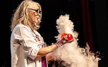 Mad scientist holding a beaker with a red liquid inside and smoke pouring out of it